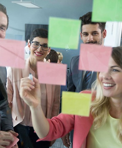 People looking at post-it notes on a board